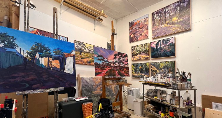 Artist's studio before clean up showing paintings and easel